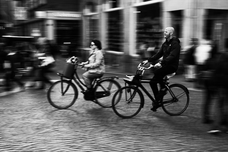 Registro feito durante viagem a cidade de Amsterdã, localizada nos Países Baixos.
fotografia de pessoas em movimento em uma bicicleta em Amsterdã, na Holanda do Norte.