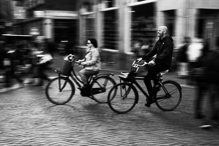 Registro feito durante viagem a cidade de Amsterdã, localizada nos Países Baixos. fotografia de pessoas em movimento em uma bicicleta em Amsterdã, na Holanda do Norte.