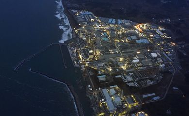 FILE PHOTO: Tokyo Electric Power Co.'s (TEPCO) tsunami-crippled Fukushima Daiichi nuclear power plant is illuminated for decommissioning operation in the dusk in Okuma town, Fukushima prefecture, Japan, in this aerial view photo taken by Kyodo
