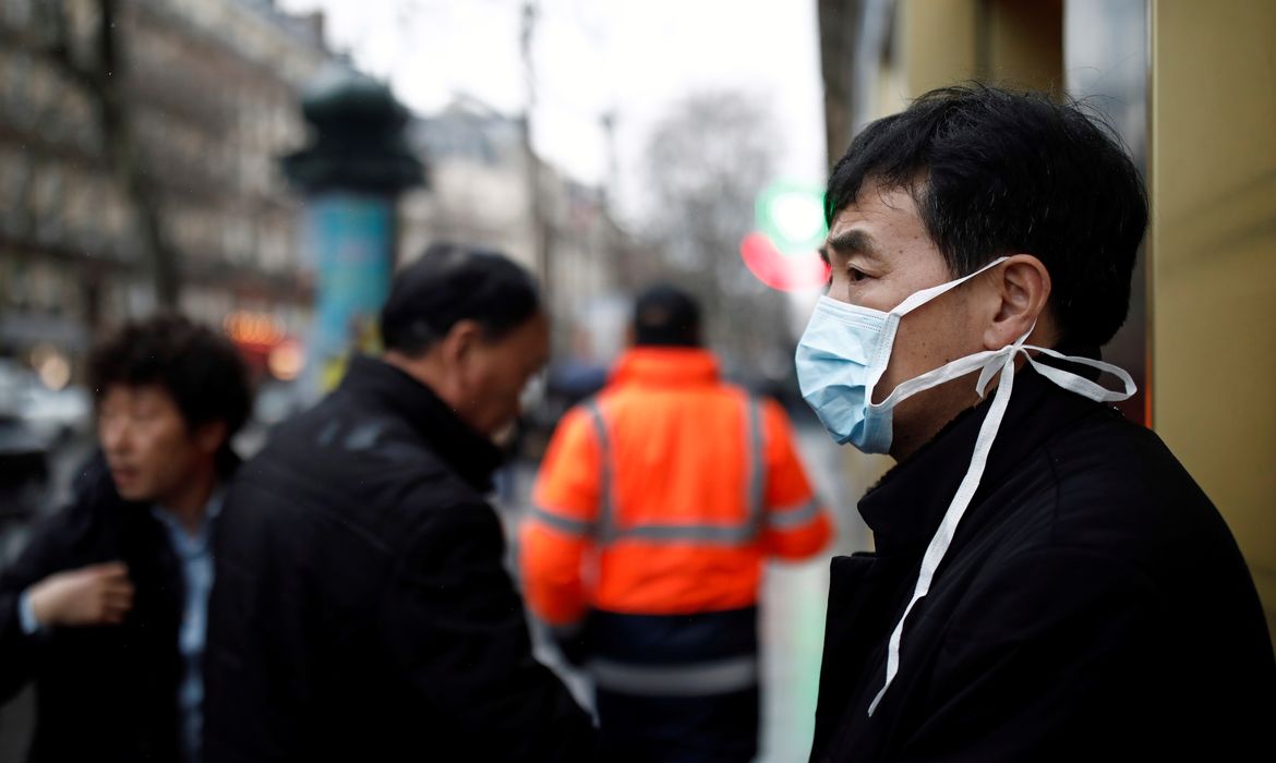 Um turista usa uma máscara protetora em frente à loja de departamentos Galeries Lafayette, em Paris, quando o país é atingido pelo novo coronavírus, na França, em 30 de janeiro de 2020. 