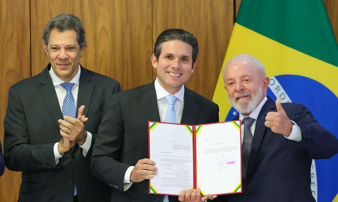 Brasília (DF) 18/03/2025 O  ministro da Fazenda, Fernando Haddad, o presidente da Câmara dos Deputados, Hugo Motta, e o presidente Luiz Inácio Lula da Silva, durante assinatura  do Projeto de Lei que prevê Isenção de Imposto de Renda (IR) para pessoas que recebem até R$ 5 mil por mês.Foto: Fabio Rodrigues-Pozzebom/ Agência Brasil