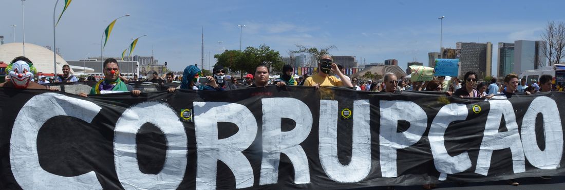Manifestantes com placa contra corrupção em  Brasília