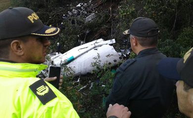 Policiais observam pedaço do avião da Chapecoense destroçado em acidente aéreo