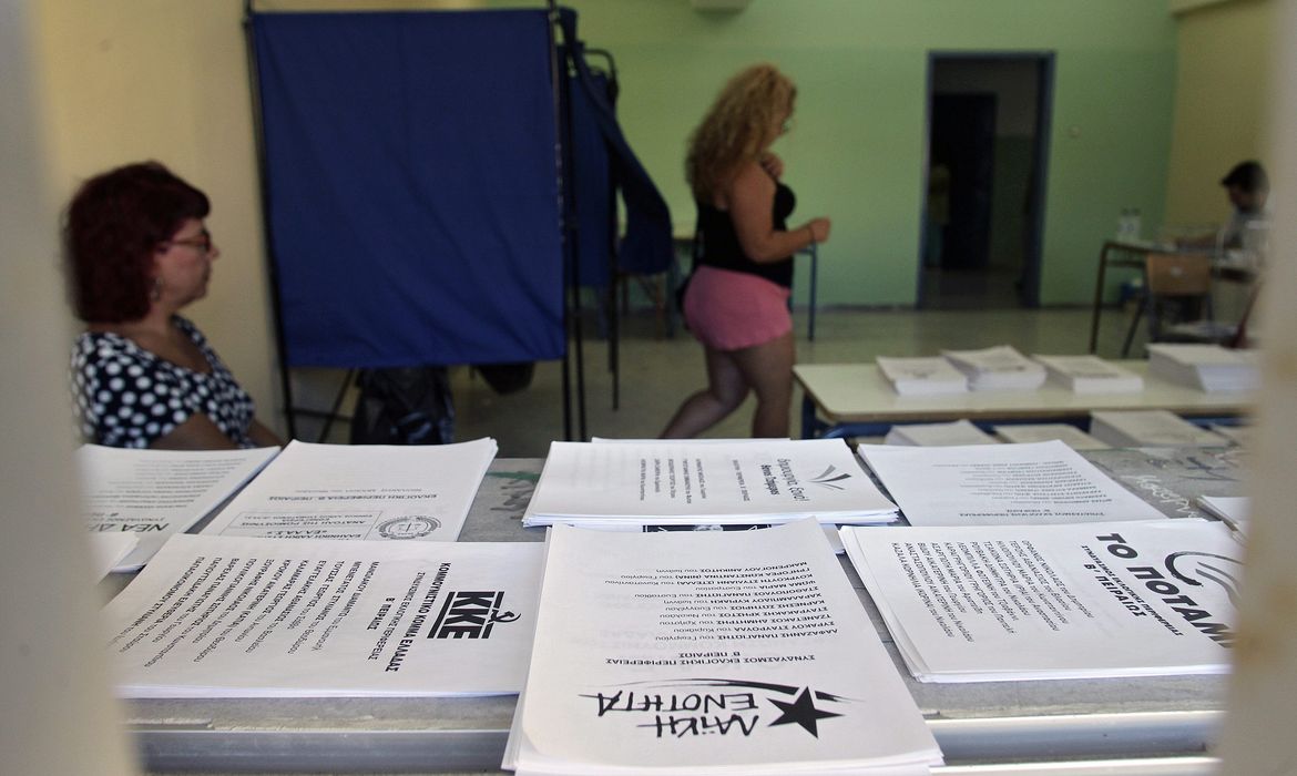 Mulher deixa cabine de votação na Grécia, nas eleições legislativas (Agência Lusa/Direitos Reservados)