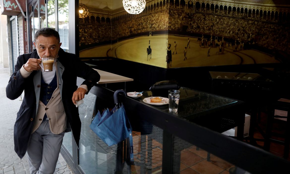 Um homem bebe durante a reabertura de um bar, já que algumas províncias espanholas podem aliviar as restrições durante a primeira fase em meio ao surto de doença por coronavírus (COVID-19), em Sevilha, Espanha