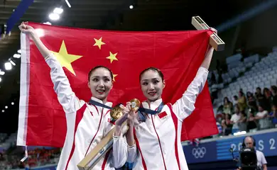 Paris 2024 Olympics - Artistic Swimming - Duet Victory Ceremony - Aquatics Centre, Saint-Denis, France - August 10, 2024. Gold medallists Liuyi Wang of China and Qianyi Wang of China pose for pictures with their medals and the flag of China. REUTERS/Gonzalo Fuentes