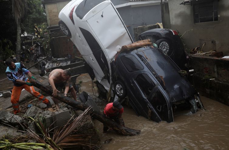 Moradores tentam remover carros danificados de um rio alagado no bairro Realengo após fortes chuvas no Rio de Janeiro, Brasil, 2 de março de 2020. REUTERS / Ricardo Moraes