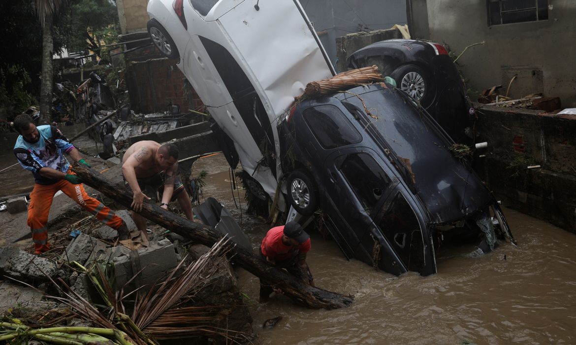 Moradores tentam remover carros danificados de um rio alagado no bairro Realengo após fortes chuvas no Rio de Janeiro, Brasil, 2 de março de 2020. REUTERS / Ricardo Moraes