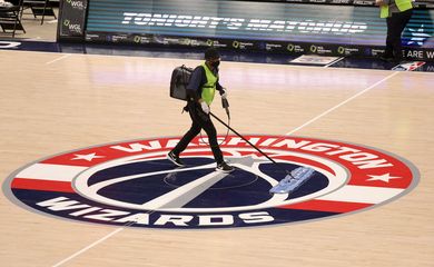 Funcionário limpa o piso da quadra da Capital One Arena, em Washington, para jogo da NBA