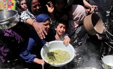 Palestinos recebem comida em Beit Lahia, norte de Gaza
8/5/2025 REUTERS/Mahmoud Issa