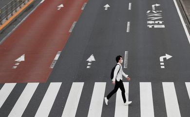 Um homem usando uma máscara protetora atravessa uma rua em Shinjuku, após o surto da doença por coronavírus (COVID-19), Tóquio, Japão, 4 de maio de 2020. REUTERS / Kim Kyung-Hoon