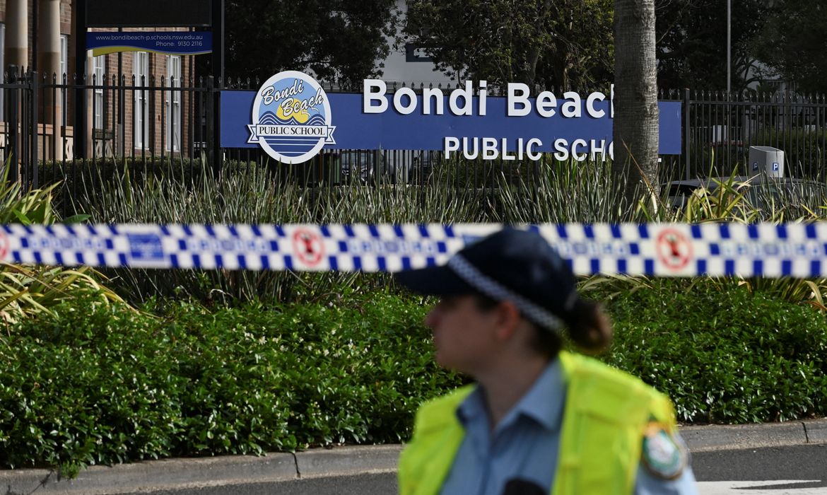 REUTERS/Flavio Brancaleone - Proibido a reprodução A police officer stands guard following the attack on a Jewish holiday celebration at Sydney's Bondi Beach, in Sydney, Australia, December 15, 2025. REUTERS/Flavio Brancaleone