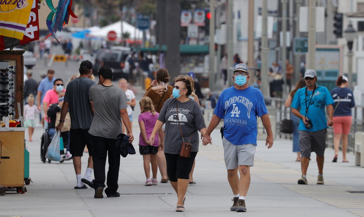 Pessoas que usam máscaras caminham ao longo do cais do oceano enquanto os Estados Unidos passaram na quinta-feira um total de mais de 4 milhões de infecções por coronavírus durante o surto global da doença por coronavírus (COVID-19) em