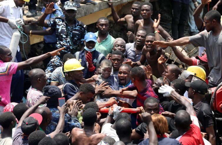 Men carry a boy who was rescued at the site of a collapsed building containing a school in Nigeria's commercial capital of Lagos, Nigeria March 13, 2019. REUTERS/Temilade Adelaja