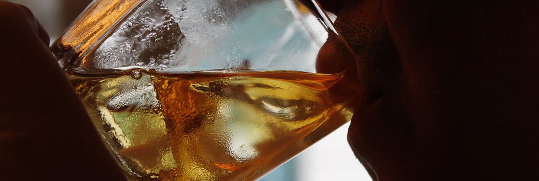 bebida alcoólica Pessoa bebendo um copo de uísque