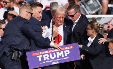Republican presidential candidate and former U.S. President Donald Trump is assisted by security personnel after gunfire rang out during a campaign rally at the Butler Farm Show in Butler, Pennsylvania, U.S., July 13, 2024. REUTERS/Brendan McDermid     TPX IMAGES OF THE DAY