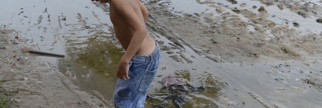 Fortaleza - Na periferia da capital cearense, crianças brincam com bola em meio à lama e sujeira
