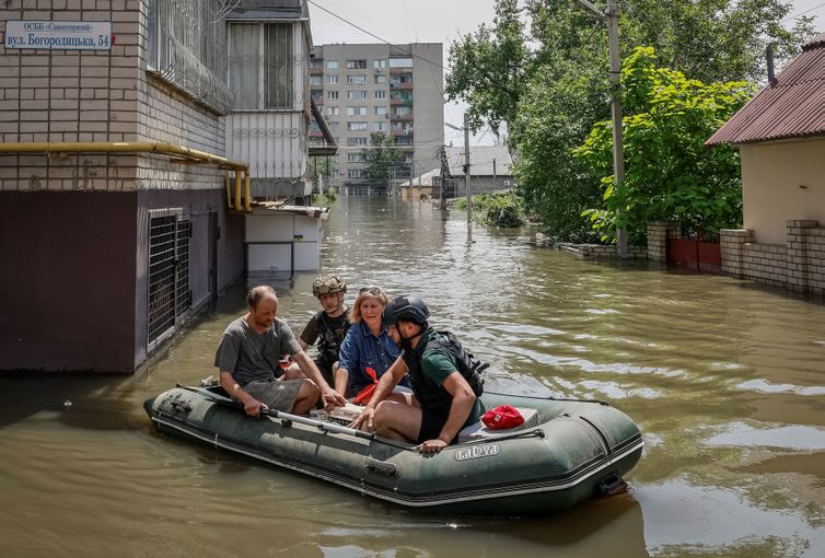 Volunteers evacuate local residents from a flooded area after the Nova Kakhovka dam breached, amid Russia's attack on Ukraine, in Kherson, Ukraine June 7, 2023. REUTERS/Alina Smutko