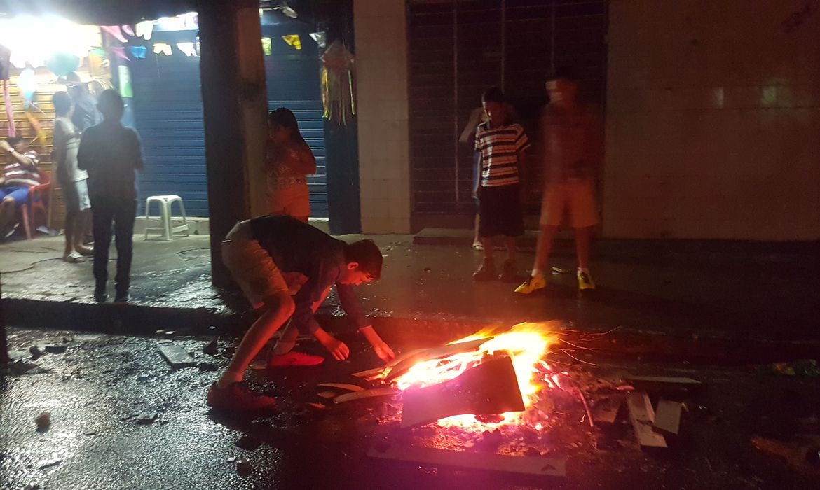 Crianças soltam bombas na noite chuvosa da véspera de São João no Recife