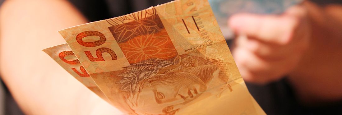 Cédulas de dinheiro Homem estende notas de dinheiro