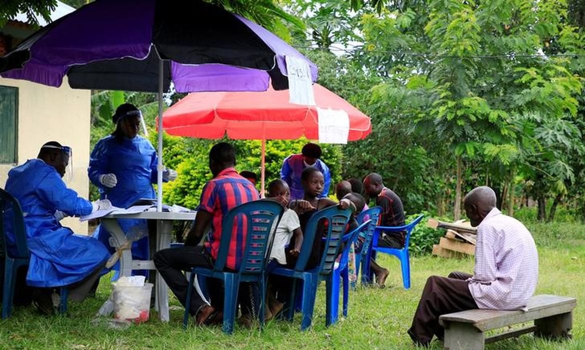 ARCHIV: Ugandische Mitarbeiter des Gesundheitswesens sprechen mit Gemeindemitgliedern, bevor sie die erste Impfung gegen das Ebola-Virus im Dorf Kirembo in Uganda durchführen