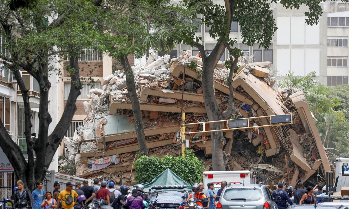 People look at the remains of a building that collapsed after earthquakes hit the country, in Caracas, Venezuela, June 25, 2026. REUTERS/Fausto Torrealba     TPX IMAGES OF THE DAY