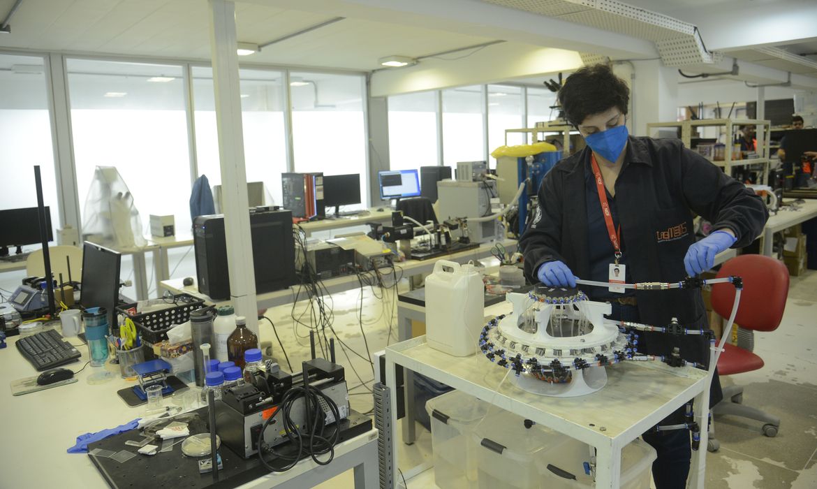 A pesquisadora Juliana Damasceno demostra equipamento para criação da Ilha de policogeração sustentável capaz de gerar eletricidade, água destilada, biocombustível e outros insumos na COPPE/UFRJ