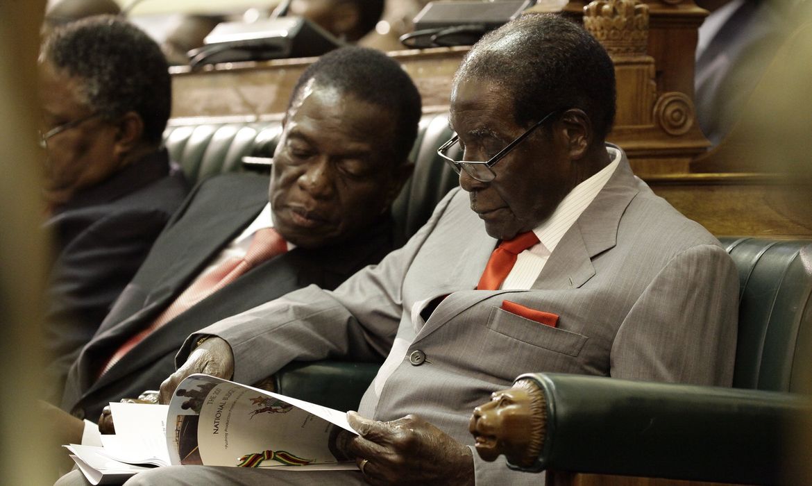 O presidente do Zimbábue, Robert Mugabe (direita), é acompanhado pelo vice-presidente Emmerson Mnangagwa (esquerda),  na Câmara do Parlamento, em Harare - Foto Agência Lusa