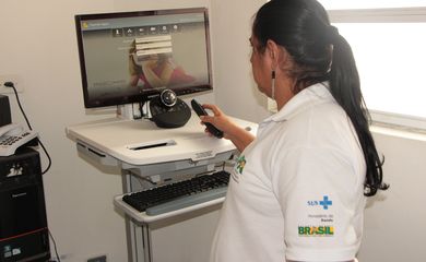 Funcionária de saúde usa sistema de atendimento remoto para consultas de saúde no Distrito Federal.