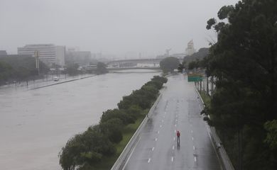 Um homem caminha sobre uma via expressa marginal parcialmente inundada do Tietê após fortes chuvas em São Paulo, Brasil, 10 de fevereiro de 2020. REUTERS / Rahel Patrasso