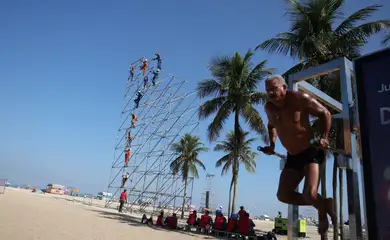 Um homem se exercita ao lado de uma estrutura para equipamentos de som para o show de Madonna na praia de Copacabana, no Rio de Janeiro, Brasil, 30 de abril de 2024. REUTERS/Pilar Olivares