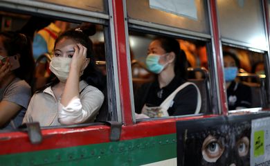 Mulheres viajam em um ônibus público usando máscaras protetoras devido ao surto de coronavírus, em Bangkok, Tailândia.