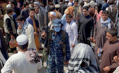 FILE PHOTO: Member of Taliban security forces stands guard among crowds of people in a street in Kabul