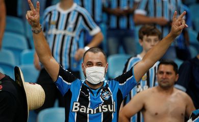 Torcedor com máscara contra coronavírus no jogo entre Grêmio e Internacional