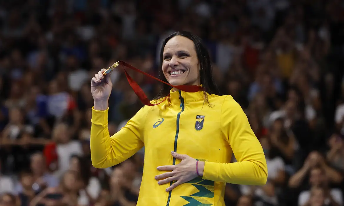 Paris 2024 Paralympics - Swimming - Women's 100m Freestyle - S12 Medal Ceremony - Paris La Defense Arena, Nanterre, France - September 4, 2024 Gold medallist Maria Carolina Gomes Santiago of Brazil celebrates on the podium Reuters/Andrew Couldridge/Proibida reprodução