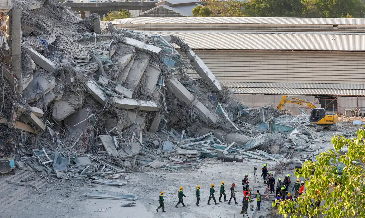 Rescue personnel gather near a building that collapsed after a strong earthquake struck central Myanmar on Friday, earthquake monitoring services said, which affected Bangkok as well with people pouring out of buildings in the Thai capital in panic after the tremors, in Bangkok, Thailand, March 28, 2025. REUTERS/Athit Perawongmetha