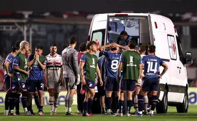 Jogadores de Nacional e São Paulo acompanham atendimento ao zagueiro Juan Izquierdo, do Nacional, após entrada de ambulância no gramado durante partida entre as duas equipes pela Copa Libertadores em São Paulo
22/08/2024 REUTERS/Carla Carniel