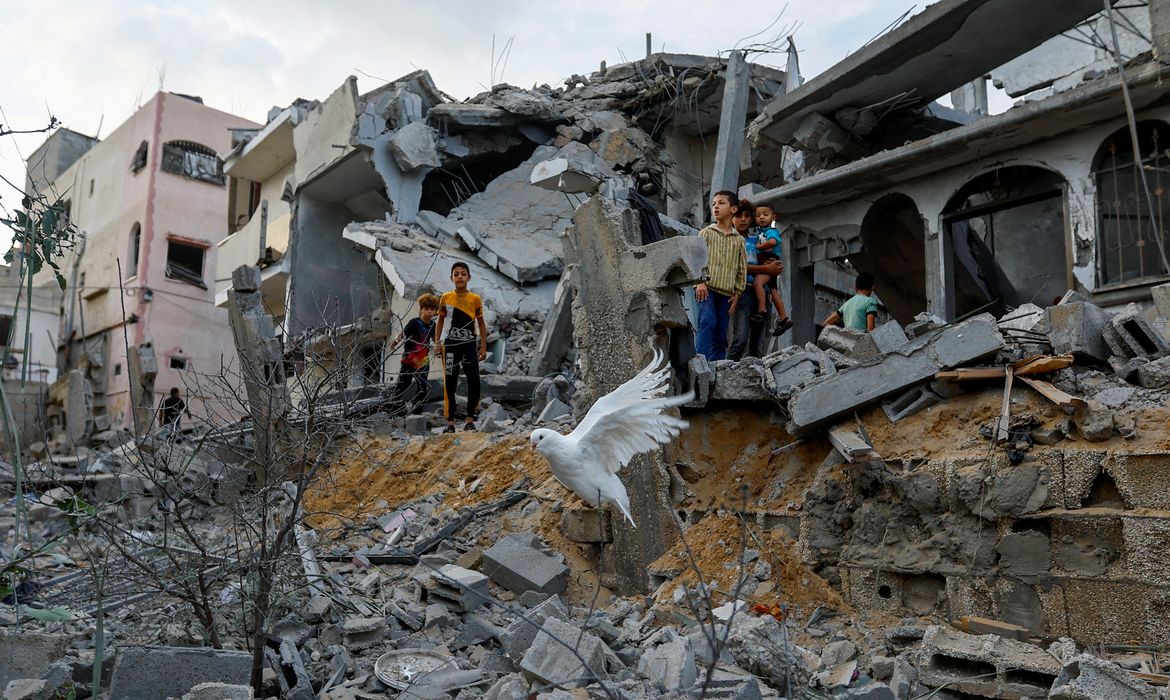 Ataques de Israel a Gaza-Um pombo sobrevoa os escombros de casas destruídas por ataques israelenses, em Khan Younis, no sul da Faixa de Gaza. 11 de outubro de 2023. REUTERS/Ibraheem Abu Mustafa