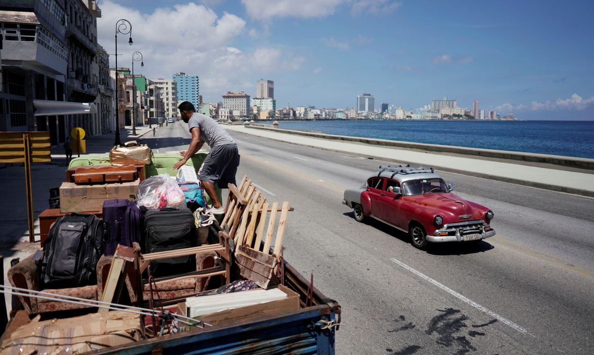 A man loads a truck with furniture from his home prior to the arrival of Storm Elsa, in Havana