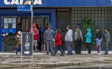 Sarandi (RS), 24/06/2024 - Pessoas fazem fila em frente ao banco Caixa Econômica Federal em busca de auxílio, após enchente que atingiu toda a região. Foto: Bruno Peres/Agência Brasil