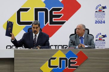 Venezuela's President Nicolas Maduro speaks next to Elvis Amoroso, head of the National Electoral Council (CNE), as he holds the credential as winner of the country's presidential election, in Caracas, Venezuela July 29, 2024. REUTERS/Leonardo Fernandez Viloria