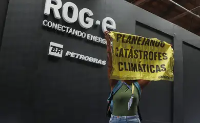 A Greenpeace activist holds up a banner that reads 