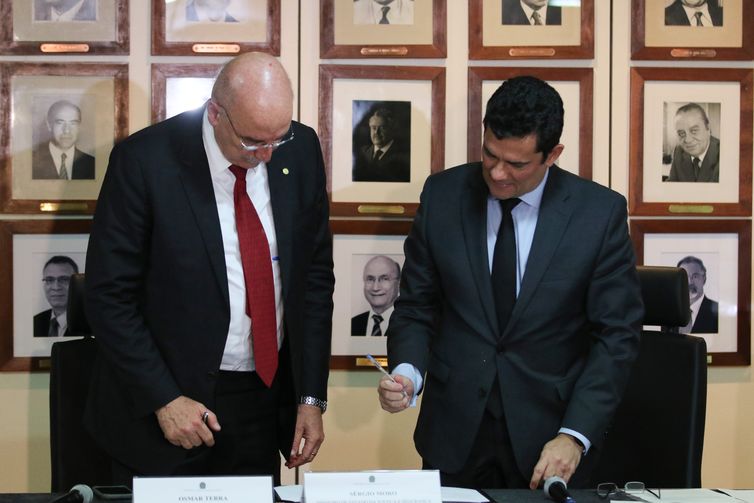 Os ministros da Cidadania, Osmar Terra, e da Justiça e Segurança Pública, Sergio Moro,  durante a cerimônia de assinatura de protocolo de intenções para o combate à pirataria .