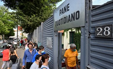 Pessoas fazem fila para receber alimentos de graça em Milão, Itália