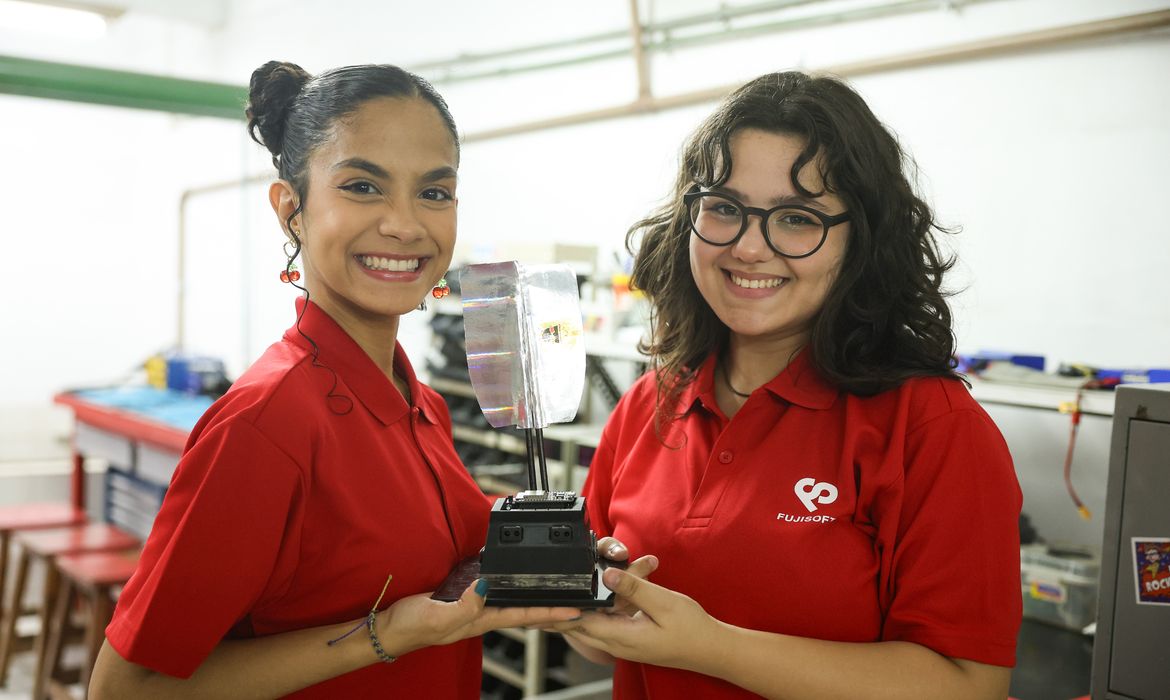 Rio de Janeiro (RJ), 20/12/2024 - A aluna de engenharia mecânica, Anne Victória Rodrigues da Costa e a de engenharia eletrônica e da computação, Lígia Bonifácio, integrantes da equipe MinervaBots, da UFRJ com o mini robô, Zé Pequeno, no laboratório de robótica da universidade, na Ilha do Fundão, no Rio de Janeiro. Foto: Tomaz Silva/Agência Brasil