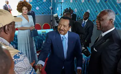 FILE PHOTO: Cameroonian President Paul Biya, 92, who is seeking an eighth term shakes hands with election observer after casting his ballot while his wife Chantal looks on, during the presidential election in Yaounde, Cameroon October 12, 2025. REUTERS/Zohra Bensemra/File Photo