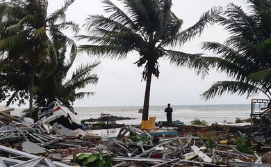 Um homem fica entre as ruínas após um tsunami na praia de Carita, em Pandeglang, na província de Banten