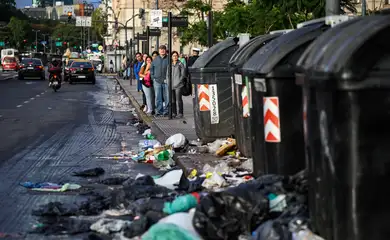 People stand at a bus stop near garbage on the ground, during a 24-hour general strike against the adjustment policy of Argentinian President Javier Milei's government, in Buenos Aires, Argentina April 10, 2025. Reuters/Agustin Marcarian/Proibida reprodução