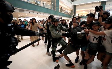 A man scuffles with a police officer as shoppers and anti-government protesters gather at New Town Plaza in Sha Tin, Hong Kong, China November 3, 2019. REUTERS/Shannon Stapleton