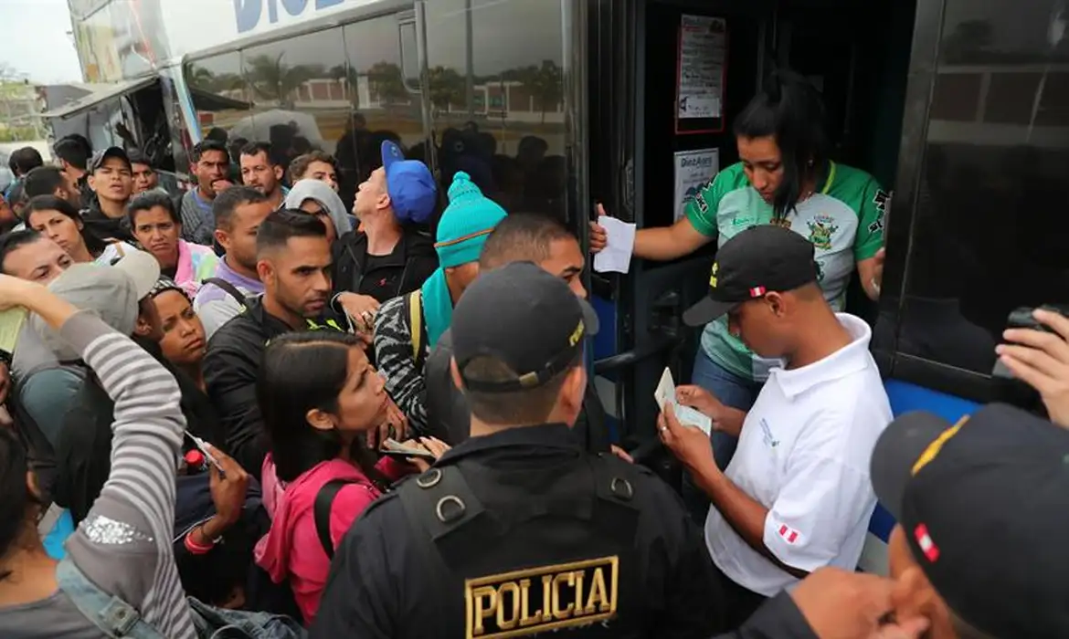 Imigrantes venezuelanos apresentam documentos ao subirem em ônibus que os levará a Trujillo, no Peru